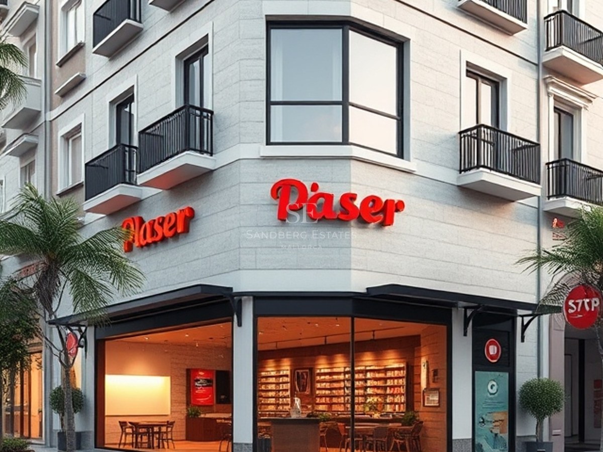 Contemporary corner building featuring natural stone cladding, large glass storefronts, and minimalist black balconies.