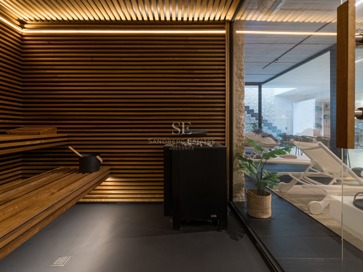 Intérieur d'un sauna de luxe avec lattes de bois horizontales, éclairage LED intégré et vue sur l'espace détente.