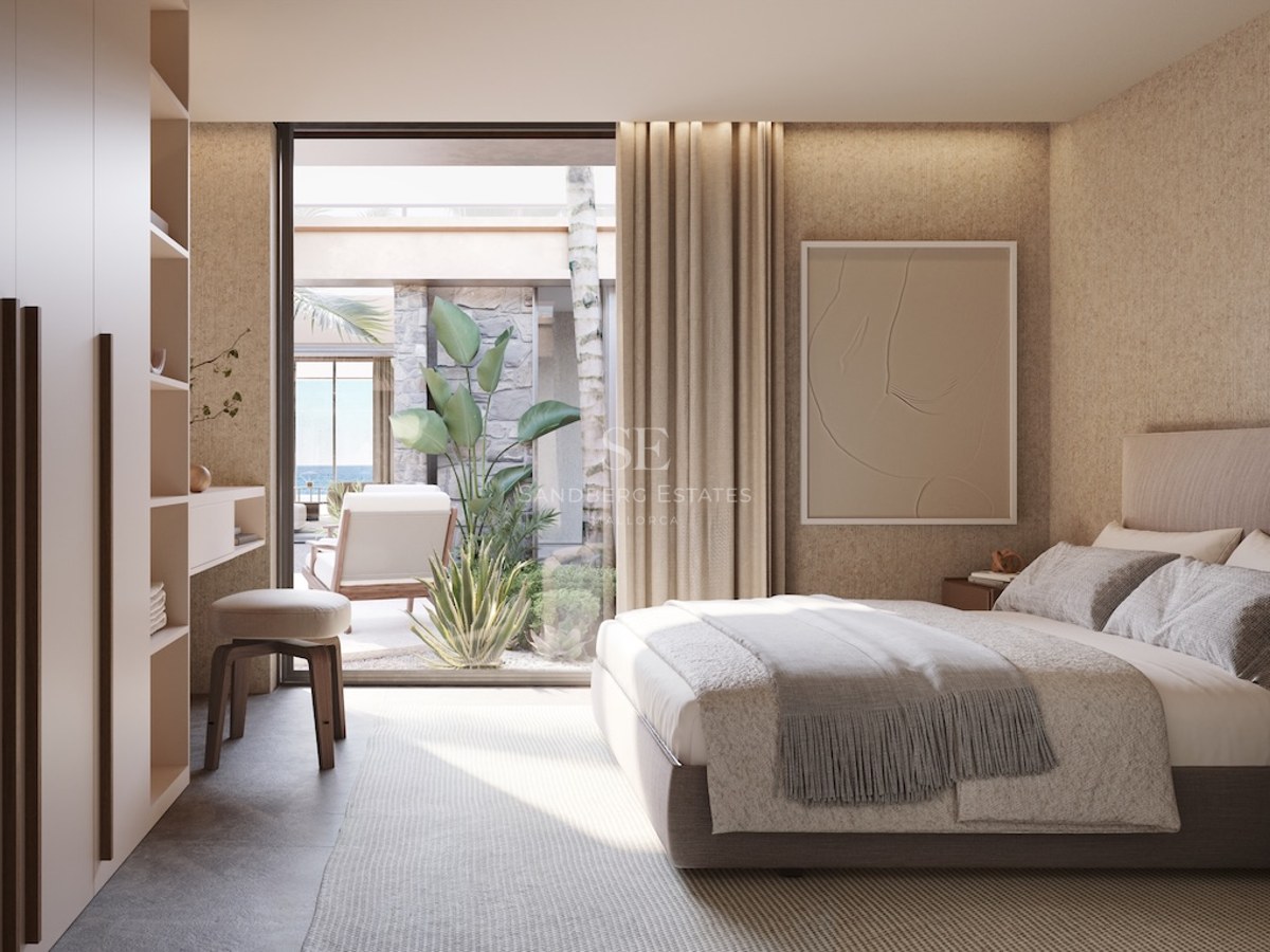 Chambre moderne aux tons neutres avec armoires encastrées et baies vitrées ouvrant sur une terrasse méditerranéenne.