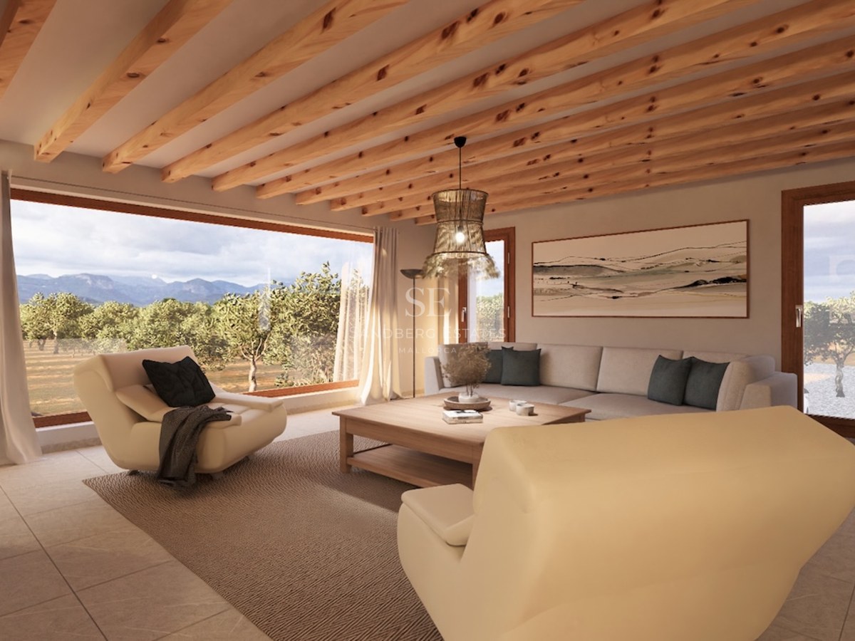 Modern living room featuring exposed wood ceiling beams, cream sofas, and a large window overlooking mountains.