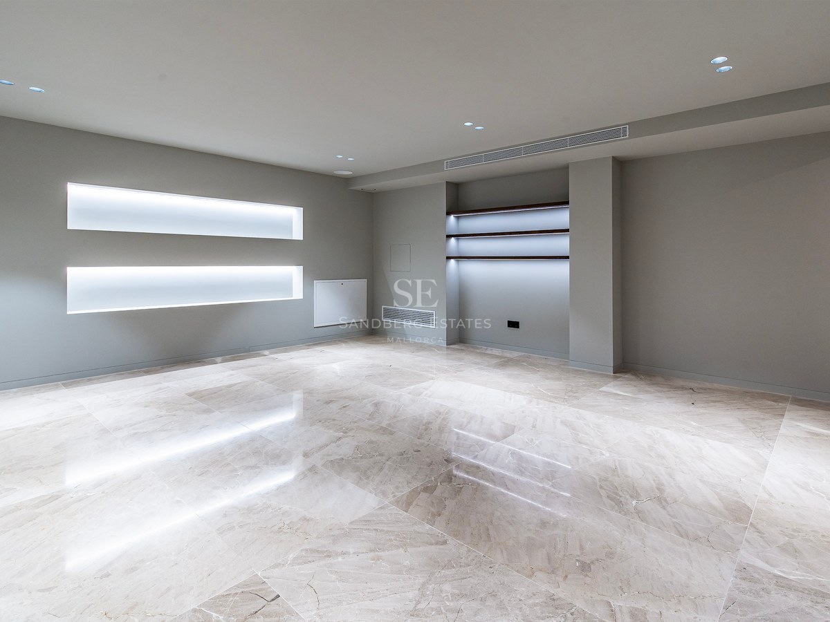 Empty modern room featuring polished marble floors, gray walls, and integrated LED lighting in wall niches.