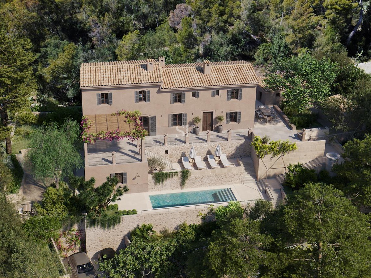Vue aérienne d'une villa en pierre sur trois niveaux avec piscine, toit en terre cuite et forêt de pins.