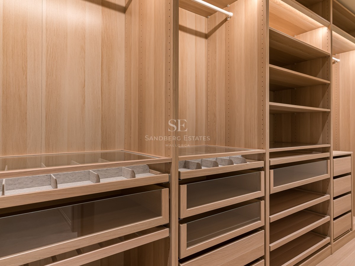 Vestidor moderno de roble claro con cajones de cristal, organizadores de joyas e iluminación LED integrada.