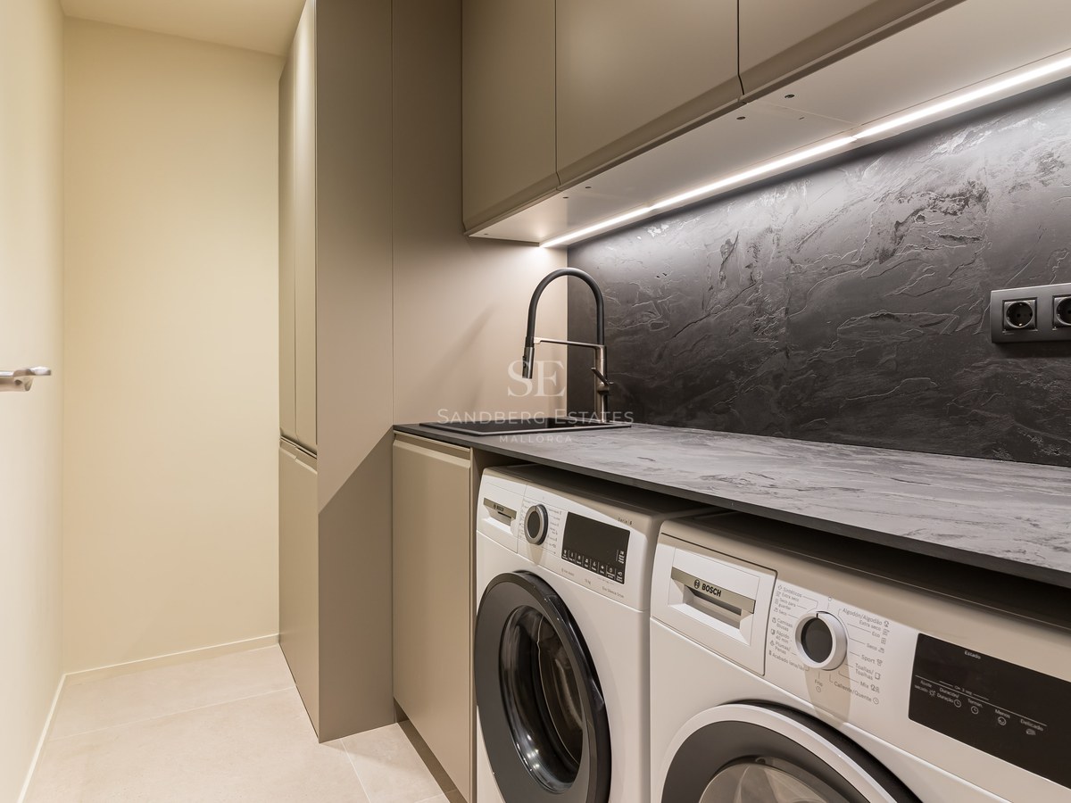 Área de lavandería contemporánea con lavadora y secadora Bosch, salpicadero oscuro texturizado y luces LED.