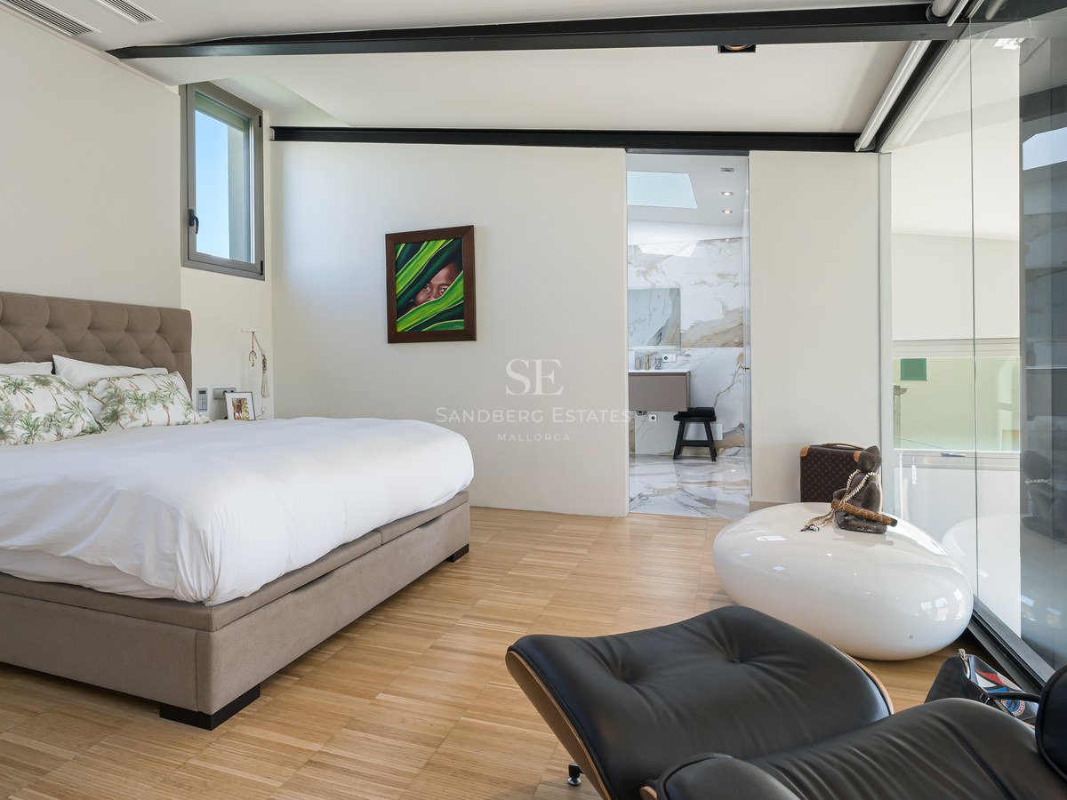 Modernes Schlafzimmer mit Eichenparkett, gepolstertem Kopfteil und Blick in das angrenzende Marmorbad.