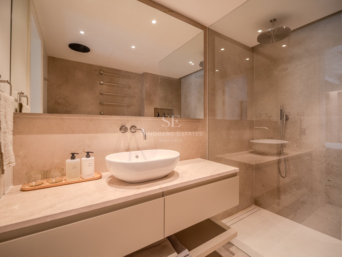 Salle de bain moderne avec vasque à poser, plan de travail en marbre et douche à l'italienne vitrée.