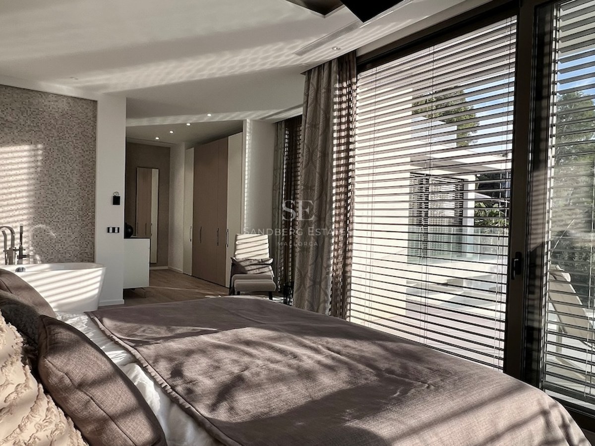 Imagen de una lujosa vivienda con piscina, jardín exuberante y arquitectura moderna. Iluminación natural y acabados de alta calidad.