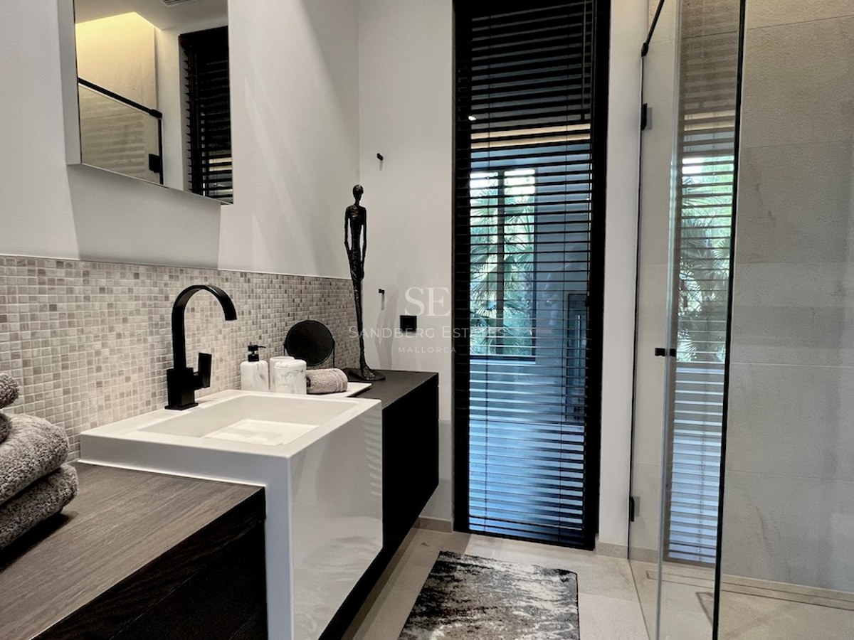Vista exterior de una moderna vivienda con piscina, jardín exuberante y arquitectura minimalista. Iluminación cálida y diseño contemporáneo.