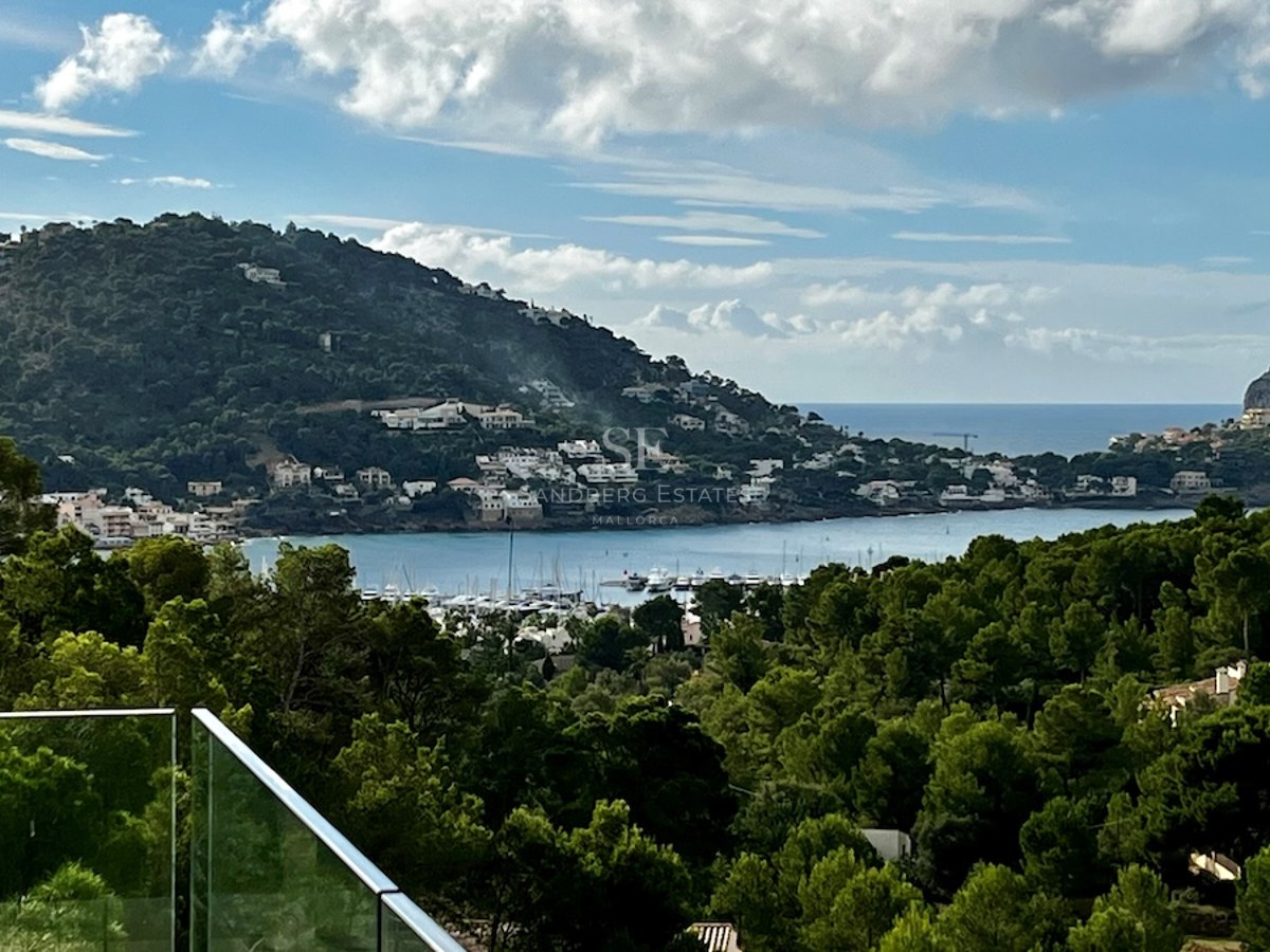 Vista panorámica de una moderna piscina infinita con tumbonas y vistas al mar. Diseño elegante y minimalista. Cielo azul y arquitectura contemporánea.