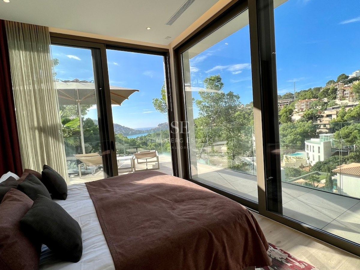Amplia terraza con piscina rodeada de vegetación exuberante. Diseño moderno con mobiliario elegante y vistas panorámicas.