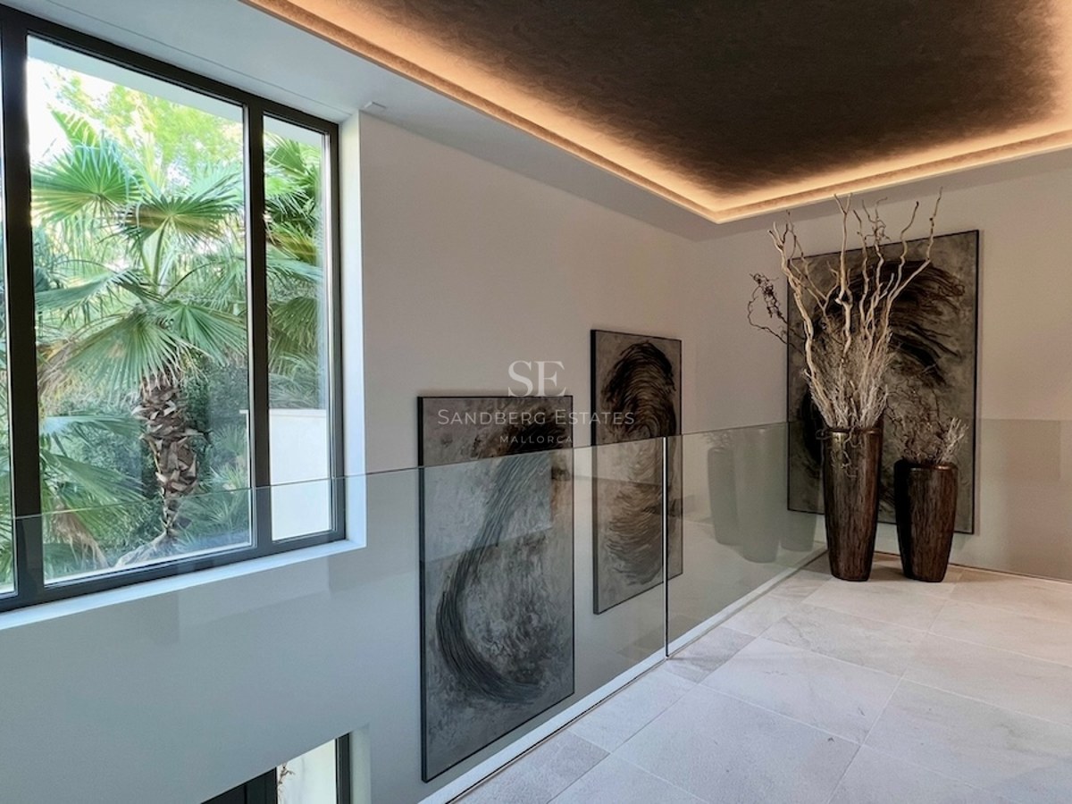 Vista exterior de una villa de lujo con piscina, rodeada de jardín. Arquitectura moderna y elegante con acabados de alta calidad.
