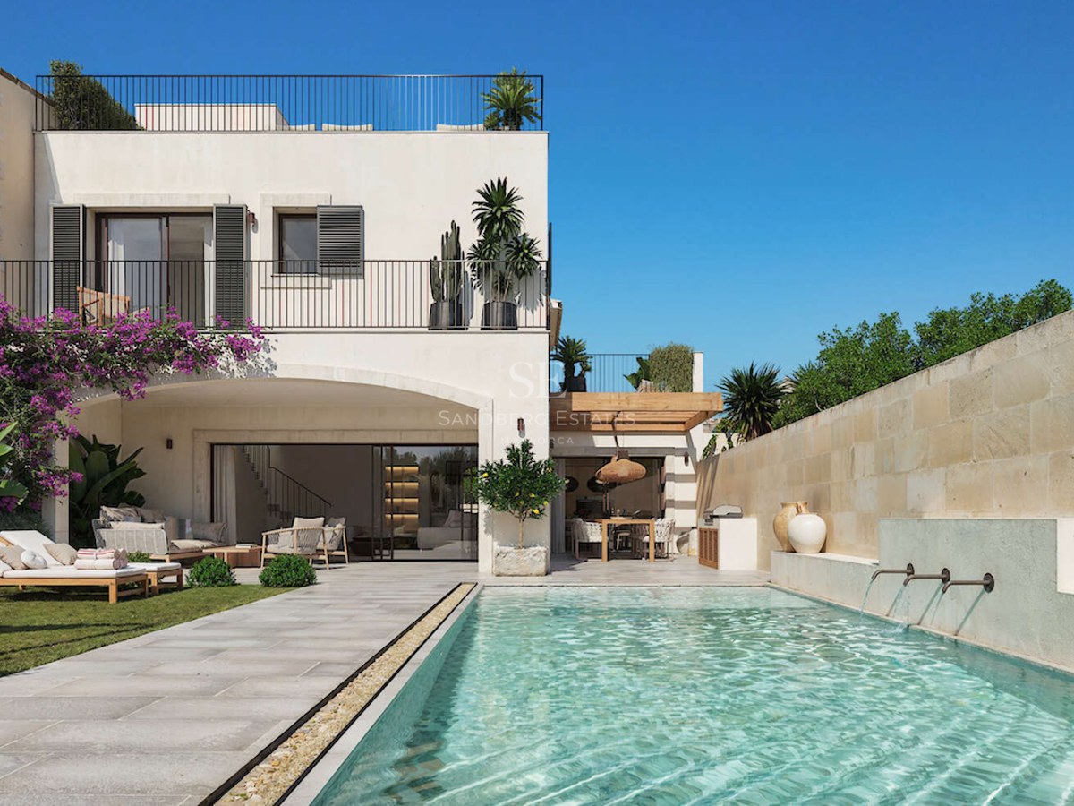 Extérieur de villa de luxe avec piscine turquoise, chaises longues sur gazon et terrasse en pierre naturelle.