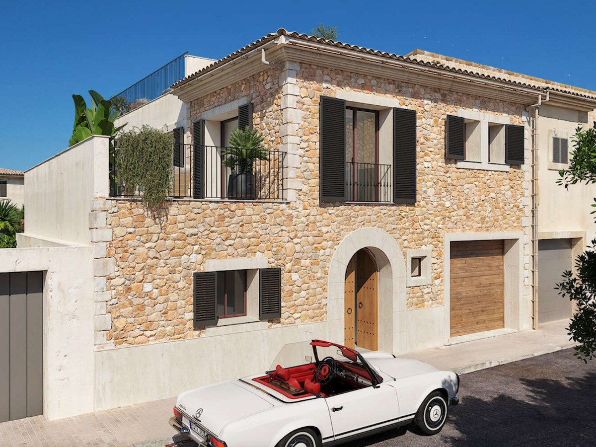 Vue extérieure d'une villa de deux étages en pierre avec volets sombres et cabriolet classique blanc.