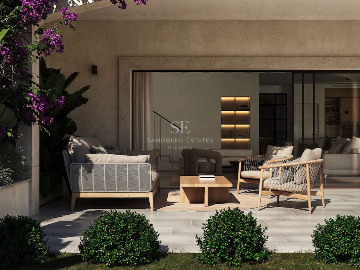 Terrasse moderne couverte avec mobilier haut de gamme, sol en pierre et vue sur un intérieur ouvert.