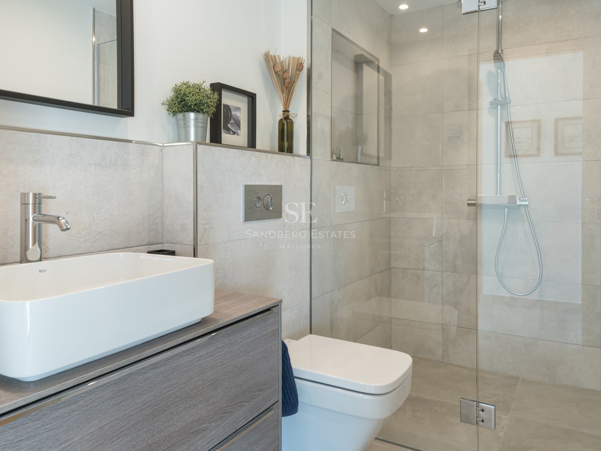Contemporary bathroom featuring a white vessel sink, grey wood vanity, glass walk-in shower, and grey stone tiles.