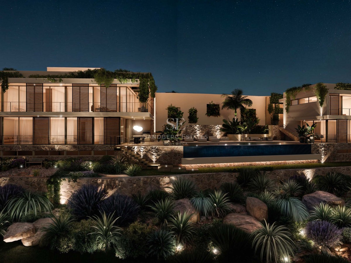 Vue nocturne d'une villa de luxe avec piscine éclairée, murs en pierre naturelle et baies vitrées.