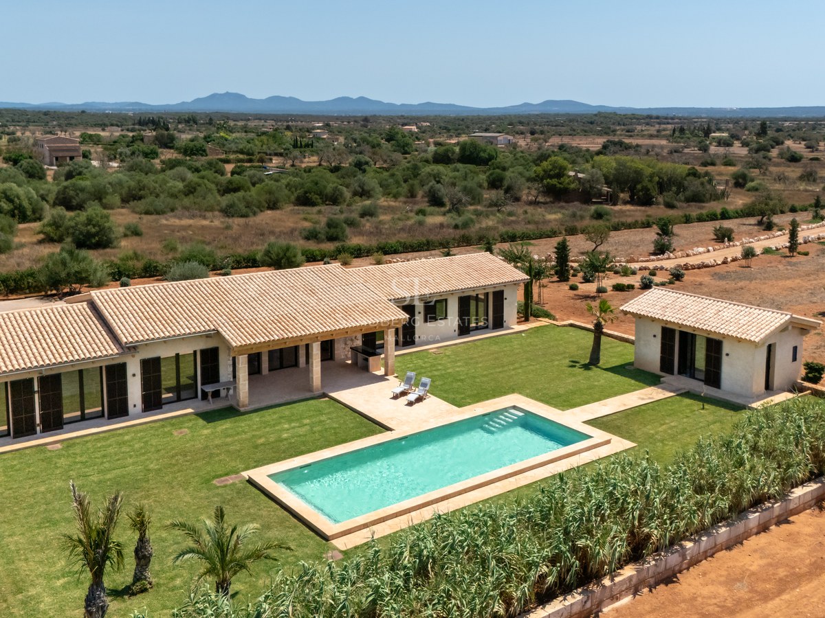 Vue aérienne d'une villa contemporaine de plain-pied avec piscine, jardin gazonné et toit en tuiles.