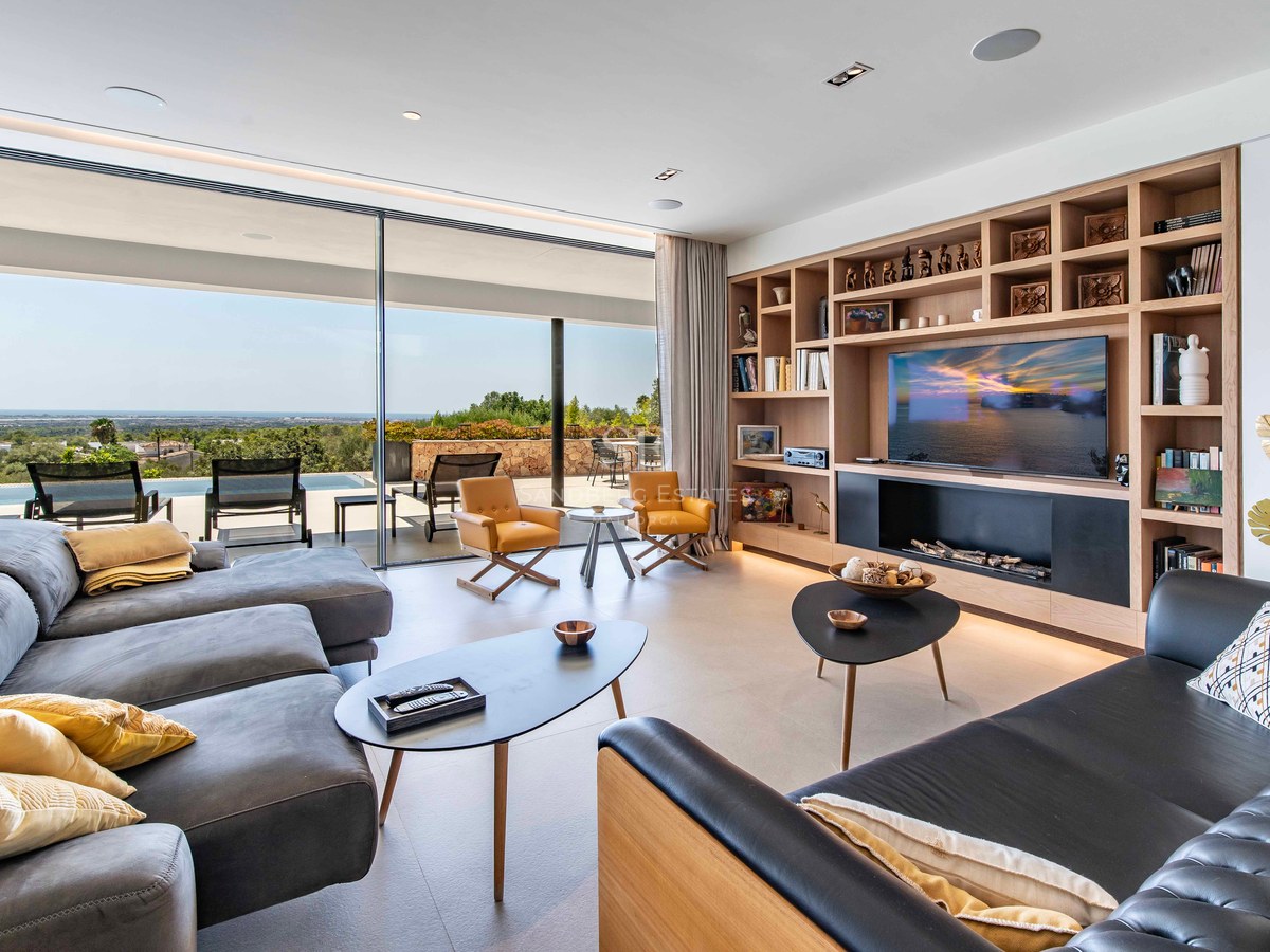 Contemporary living room featuring floor-to-ceiling glass doors, infinity pool access, and expansive coastal views.