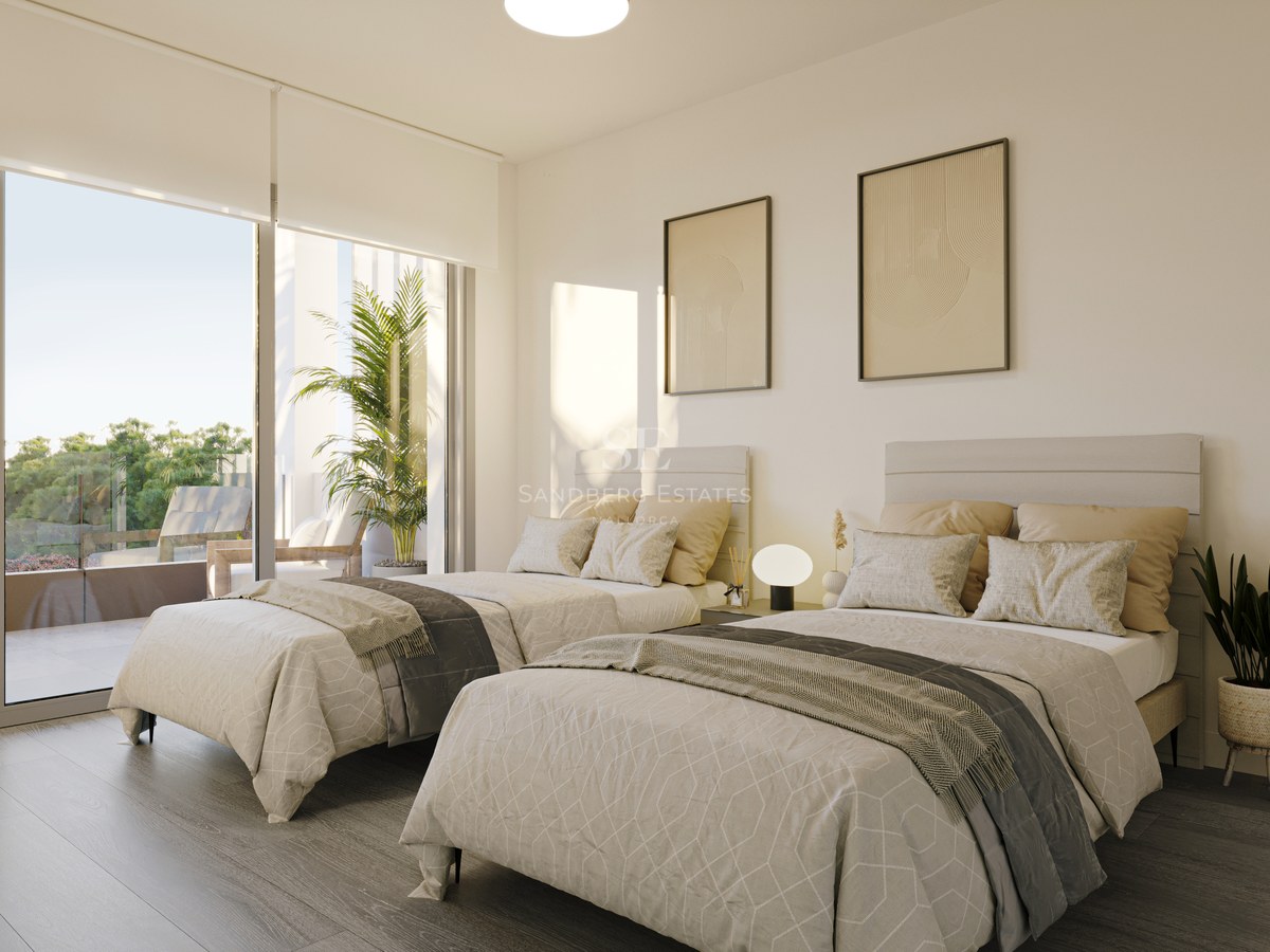 Bright bedroom featuring twin beds, wooden flooring, and large glass sliding doors opening to a private terrace.