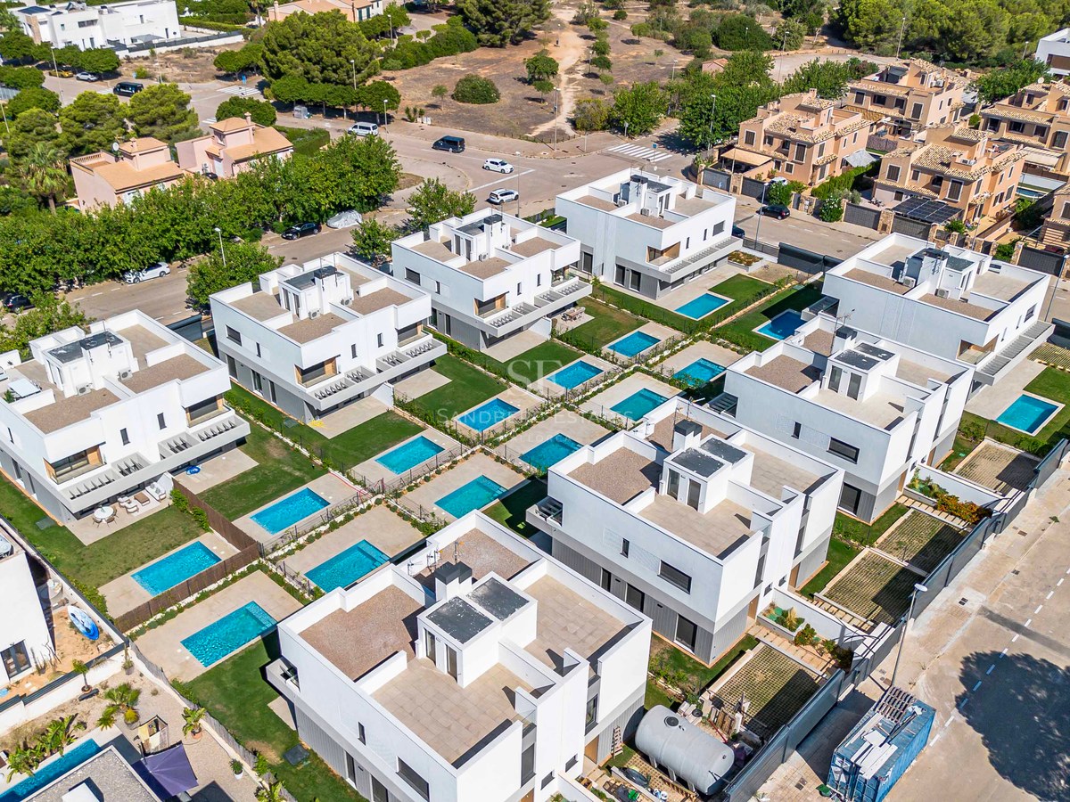 Luftaufnahme zeitgenössischer weißer Villen mit privaten türkisfarbenen Pools und gepflegten Gärten.