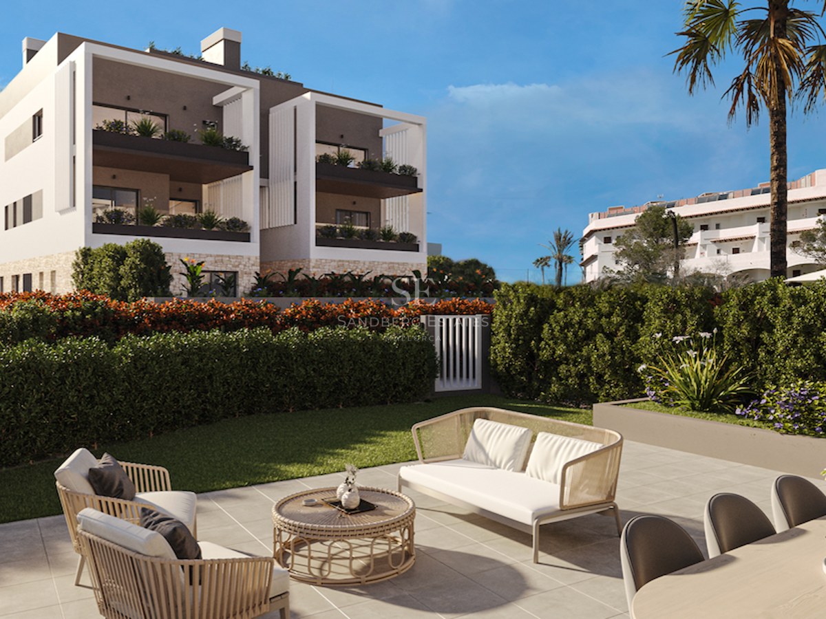 Contemporary outdoor terrace with lounge furniture and dining area overlooking a manicured lawn and modern building.