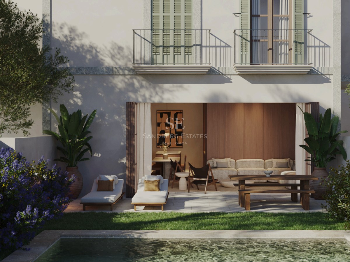 Terraza de lujo con muebles de madera, tumbonas junto a la piscina y fachada con contraventanas verdes.