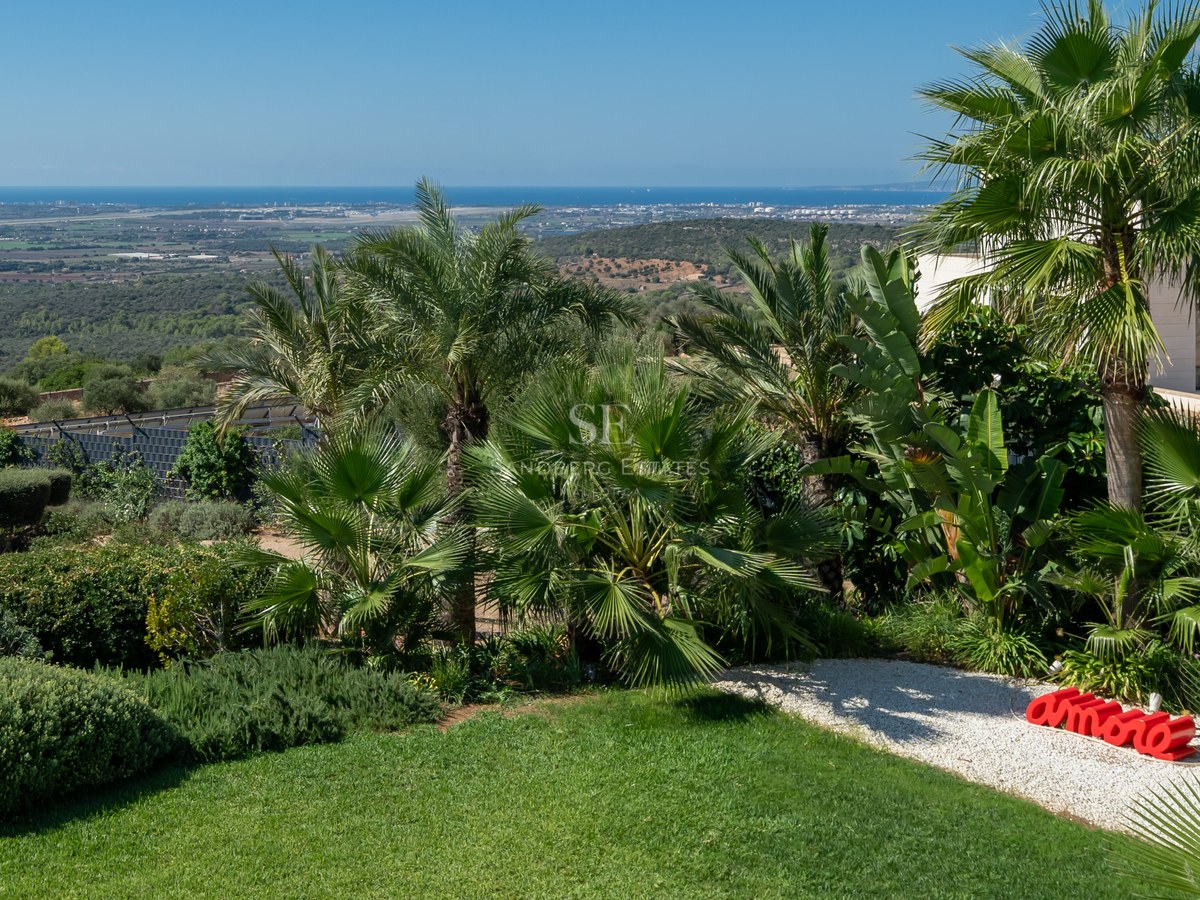 Vista exterior de villa moderna con piscina infinita, jardín exuberante y amplias terrazas. Arquitectura minimalista y diseño elegante.