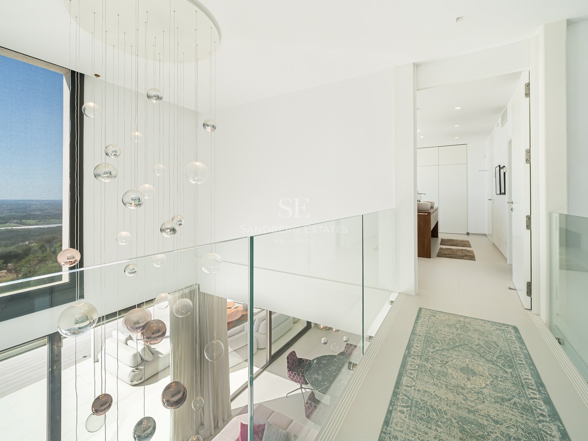 Vista exterior de una villa moderna con piscina infinita, jardín y grandes ventanales. Arquitectura minimalista y diseño paisajístico elegante.