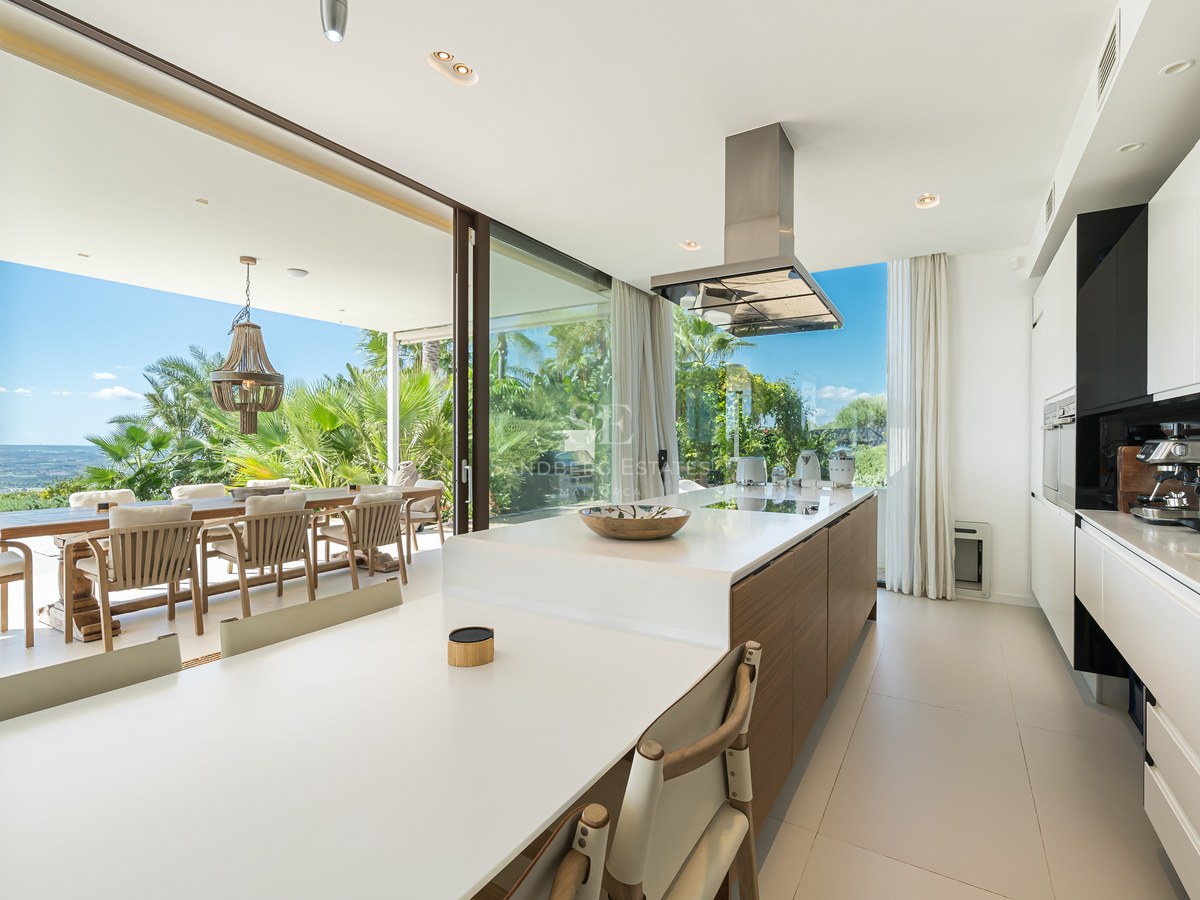 Vista exterior de villa de lujo con piscina, jardín exuberante y arquitectura moderna. Ideal para familias y entretenimiento.