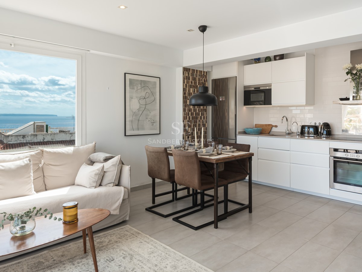 Utsikt över infinitypoolen med vidsträckt havsutsikt från en modern villa med elegant terrass och utemöbler.