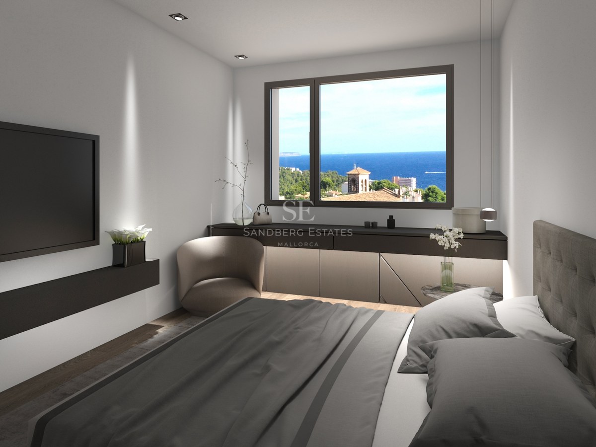 Chambre moderne avec lit gris, TV murale et fenêtre offrant une vue sur la mer bleue et le paysage côtier.