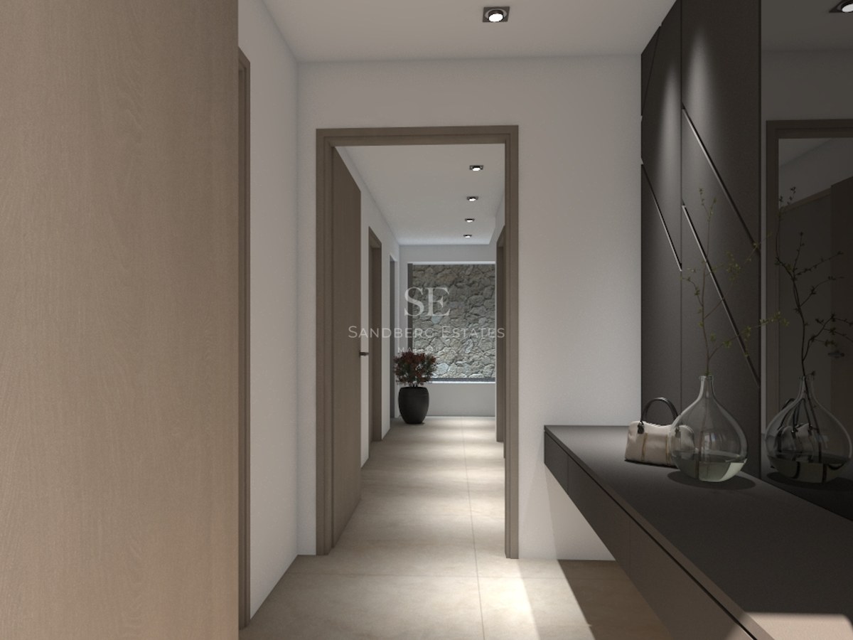 Couloir élégant avec portes en bois clair, console sombre, grand miroir et mur en pierre naturelle au fond.