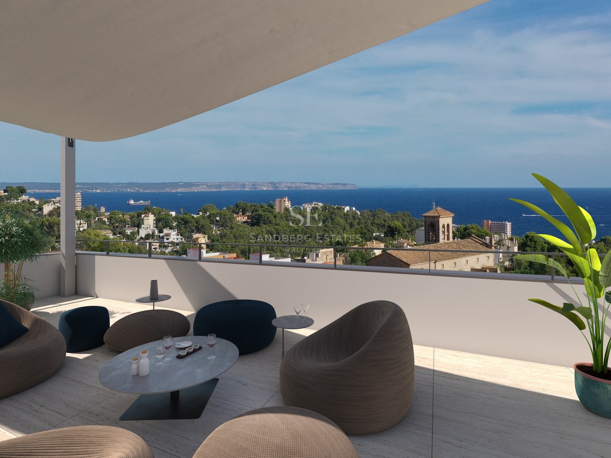 Terrasse moderne sur le toit avec sièges design offrant une vue sur une ville côtière méditerranéenne et la mer.