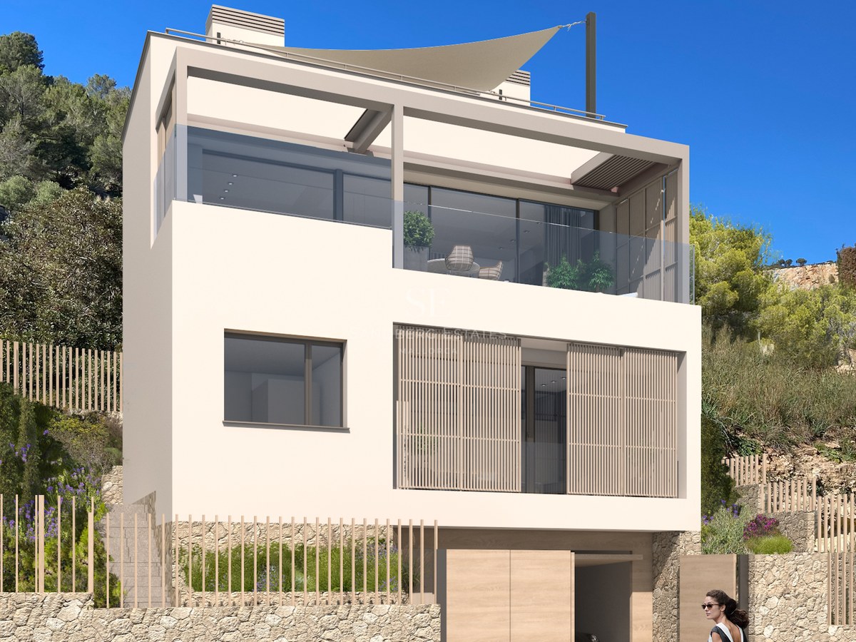 Villa moderne de trois niveaux, façade beige, balustrades en verre, persiennes en bois et mur de soutènement en pierre.
