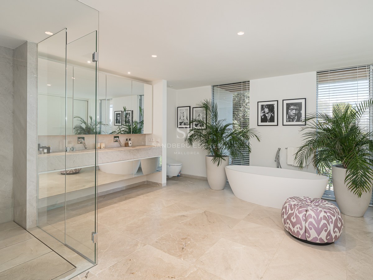Spacious master bathroom featuring a freestanding tub, glass walk-in shower, marble floors, and double vanity.