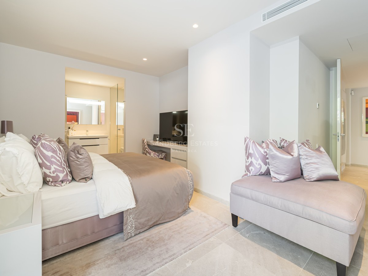 Bright master bedroom with marble floors, plush bed with lavender accents, and a view into a modern en-suite bathroom.