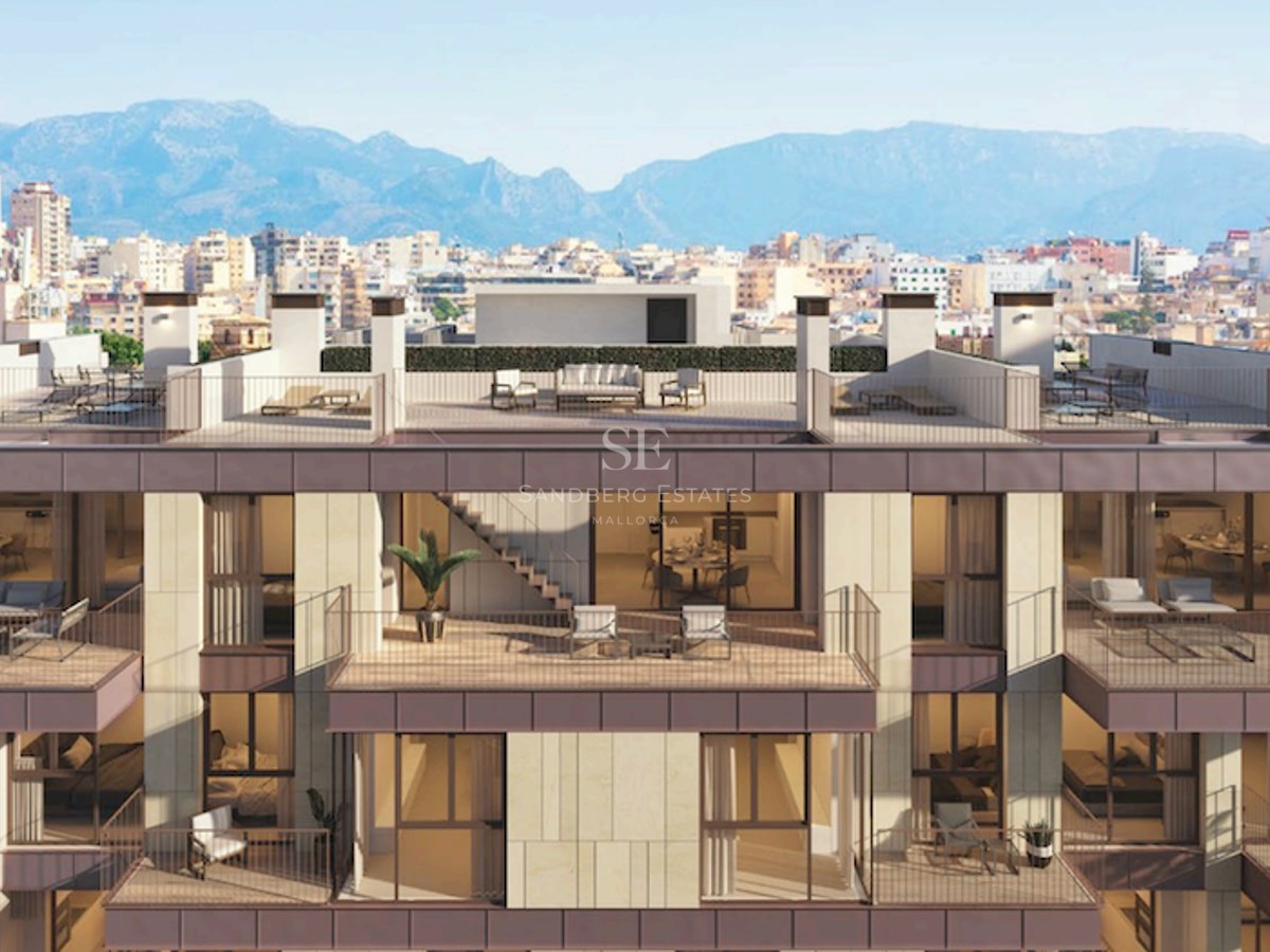 Modern building facade featuring multiple balconies, rooftop terraces, and a backdrop of city and mountains.