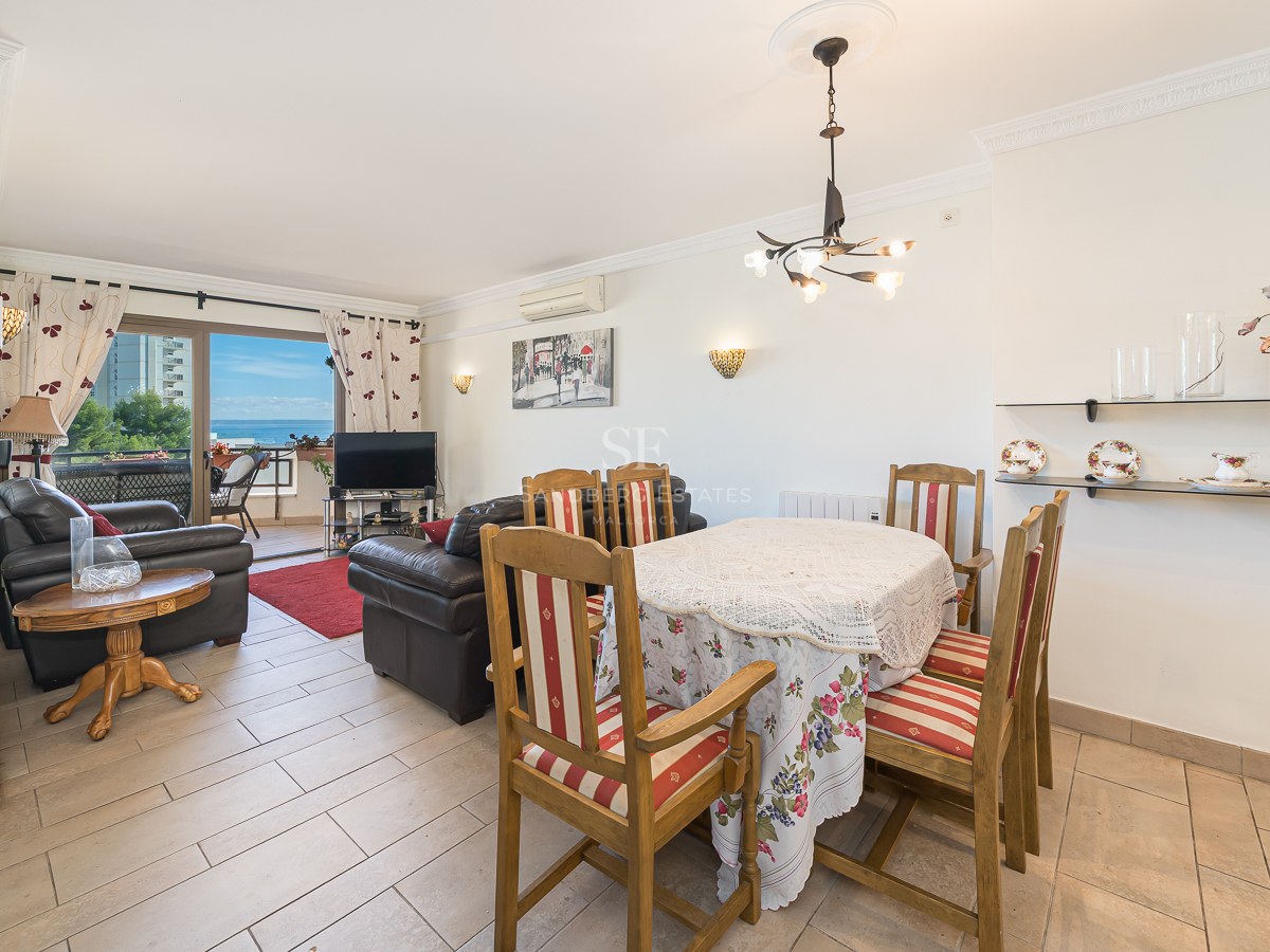 Open plan living and dining room featuring a grandfather clock, leather sofas, and a balcony overlooking the Mediterranean Sea.