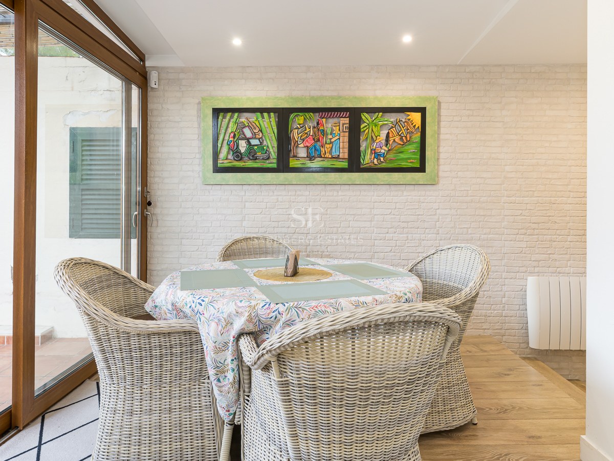 Dining area featuring wicker chairs, a white brick wall, and sliding glass doors.
