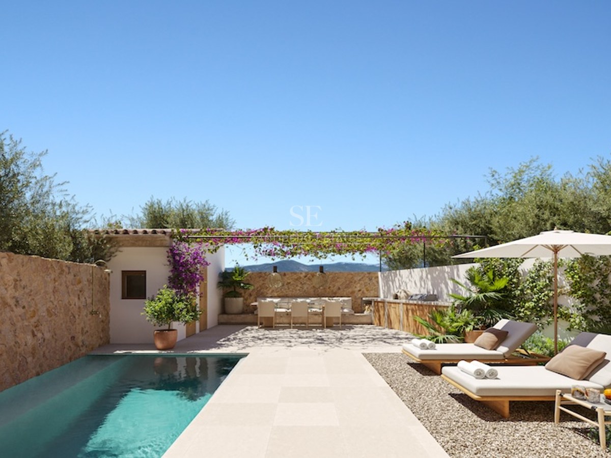Private pool area with sun loungers, outdoor kitchen, and dining under a pergola surrounded by stone walls.