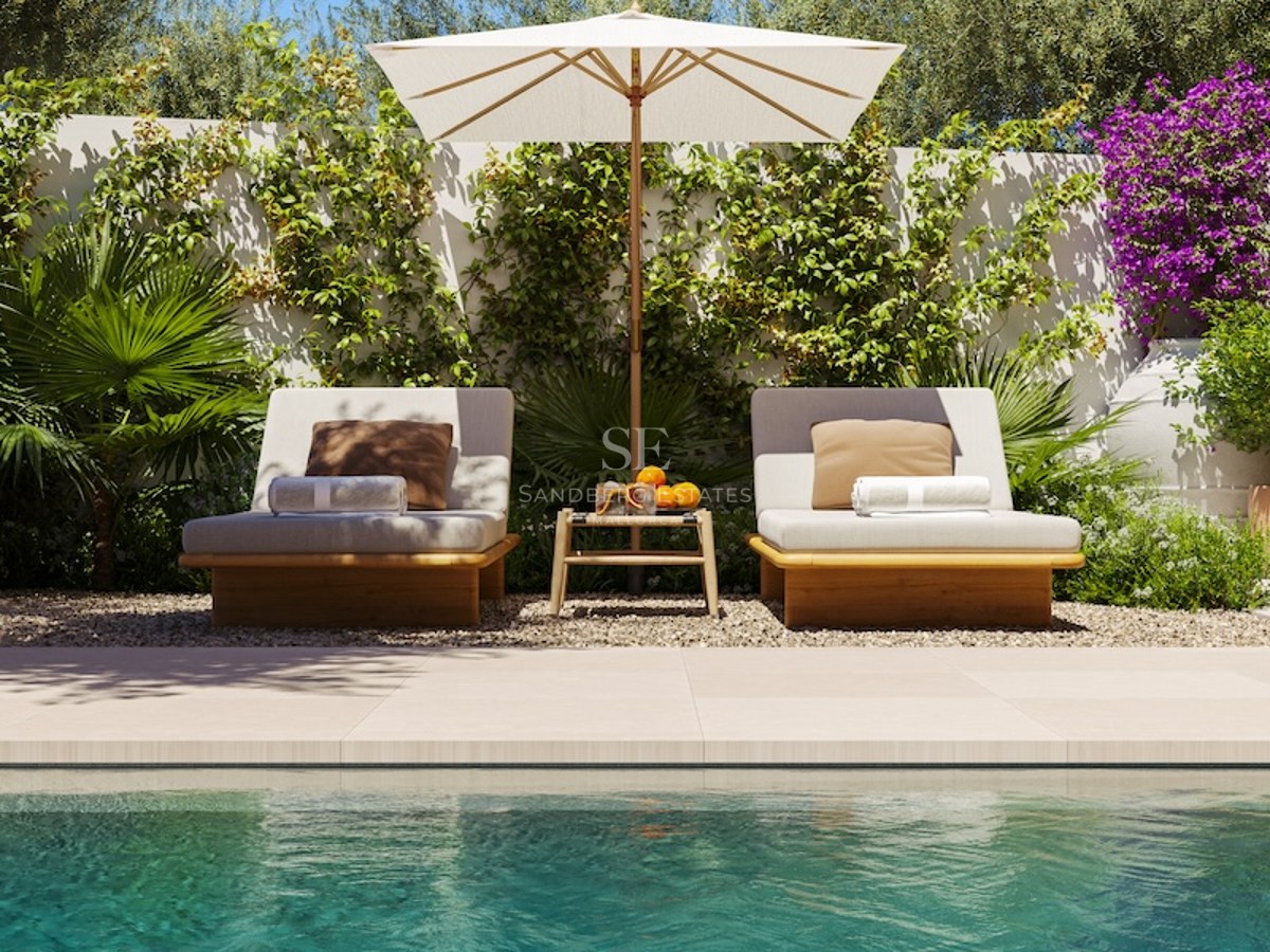 Two elegant wooden sun loungers under a white parasol next to a turquoise pool with lush green foliage.