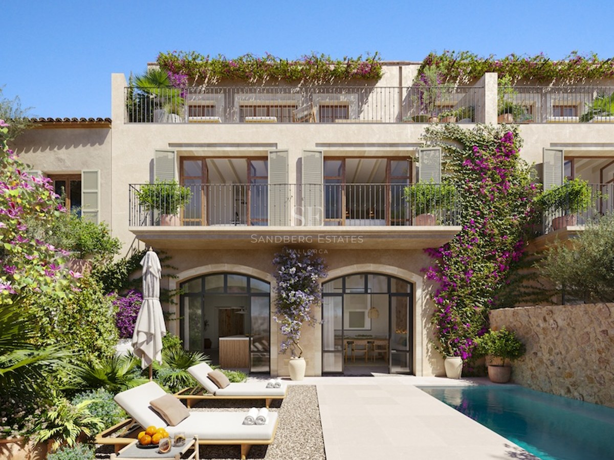 Luxury villa featuring a turquoise pool, sun loungers, stone arches, and vibrant bougainvillea under a clear blue sky.