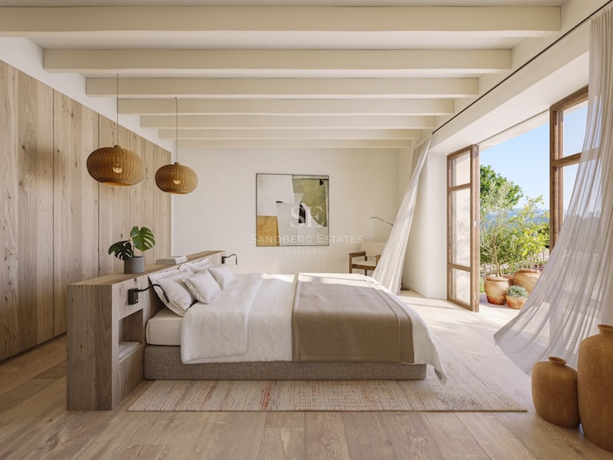 Master bedroom with wood paneling, ceiling beams, and a large open glass door leading to a sunny terrace.