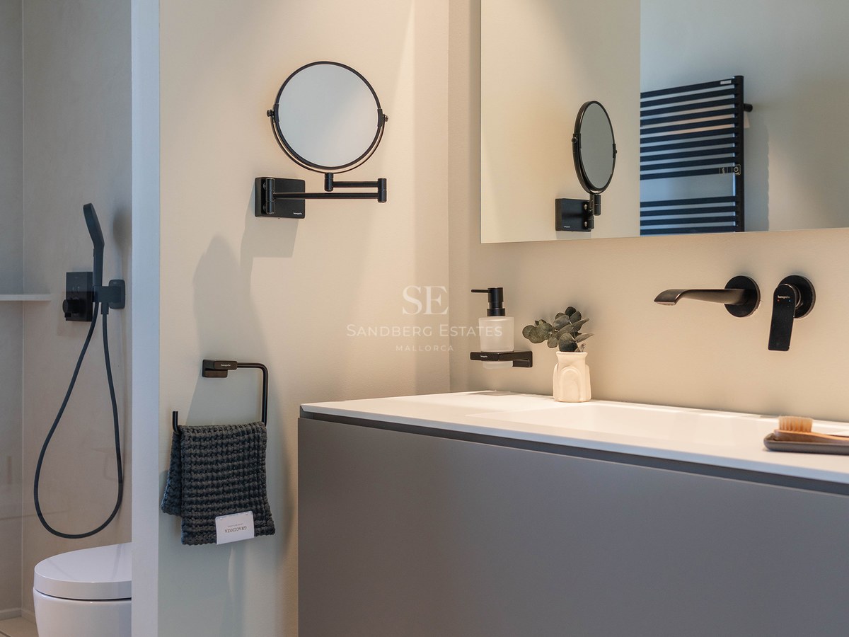 Modern bathroom featuring a grey floating vanity, matte black fixtures, and a large rectangular mirror.