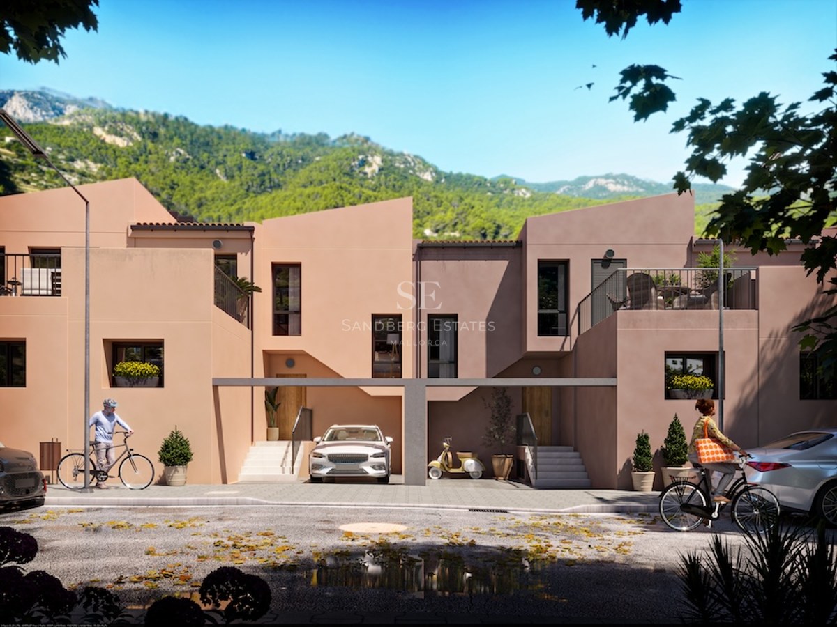 Contemporary terracotta-colored townhouses against a lush mountain backdrop with people cycling on the street.