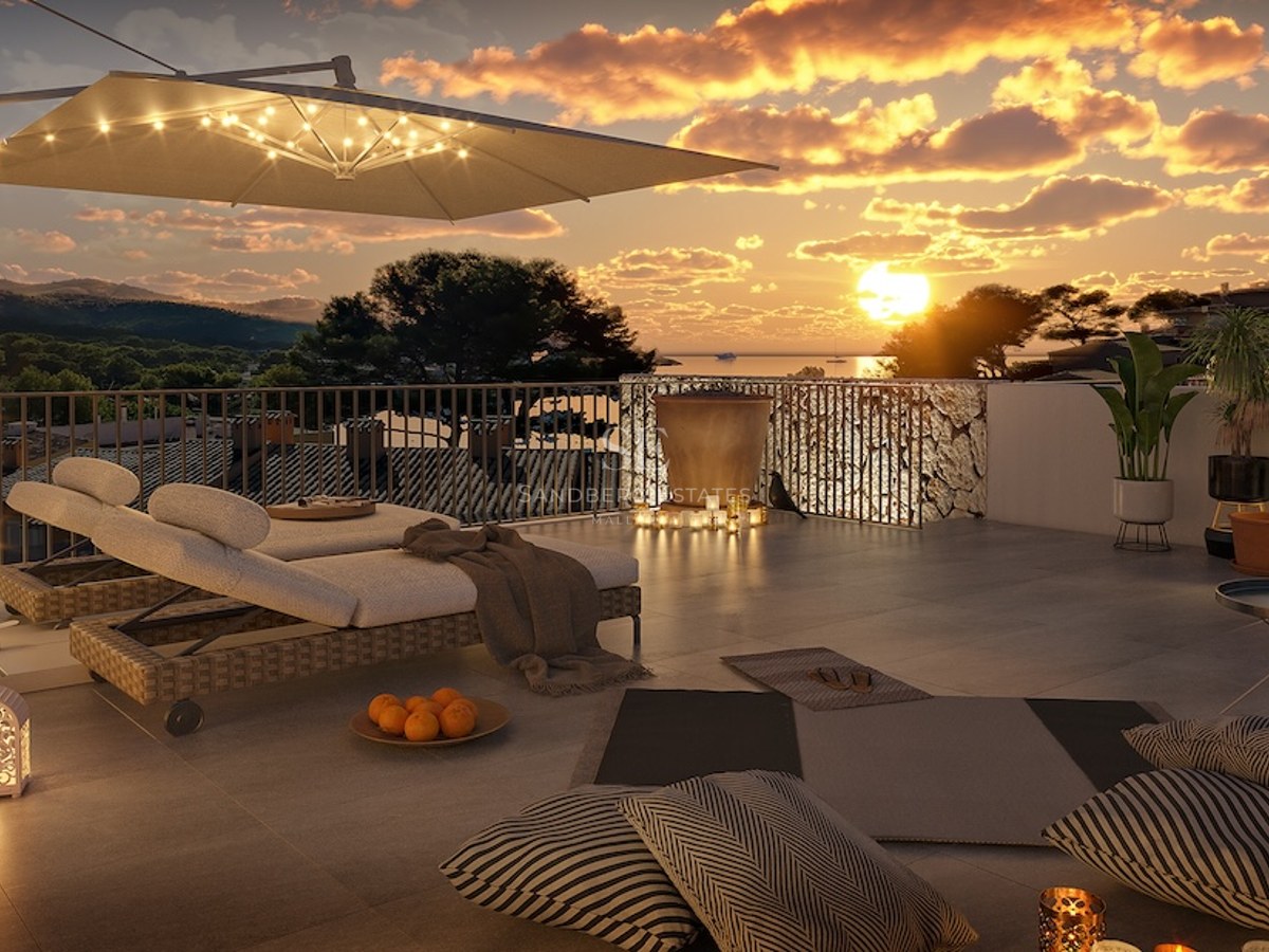 Terraza de lujo en la azotea al atardecer con tumbonas de diseño, iluminación cálida y vistas panorámicas al mar.
