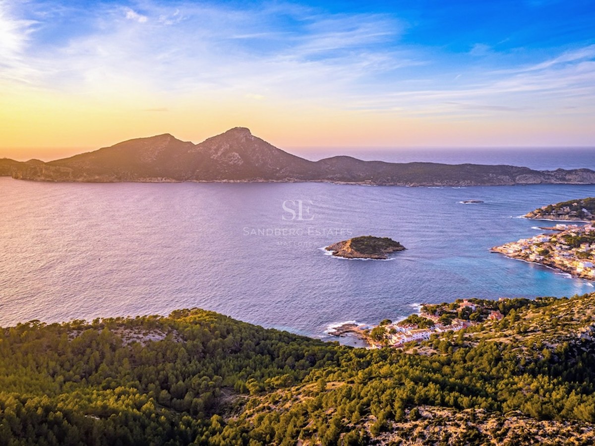 Vista aérea del mar Mediterráneo y la isla Dragonera al atardecer con luces doradas sobre la costa.