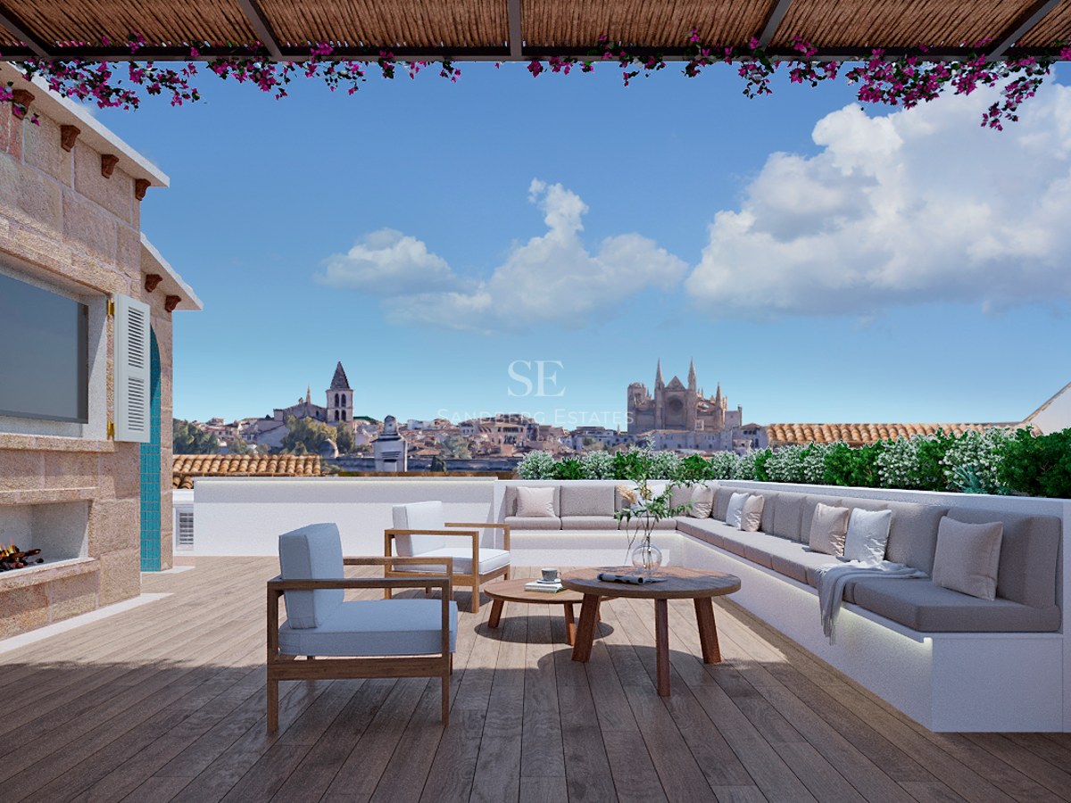 Lyxig takterrass med trädäck, bekväma sittplatser, öppen spis och panoramautsikt över stadens katedral.