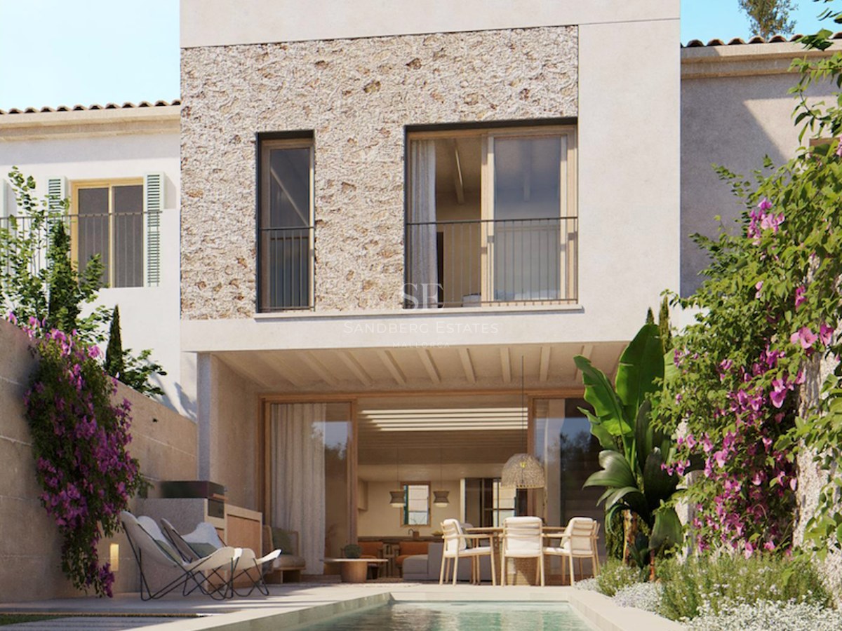 A lap pool in front of a modern white villa with natural stone cladding and vibrant bougainvillea flowers.