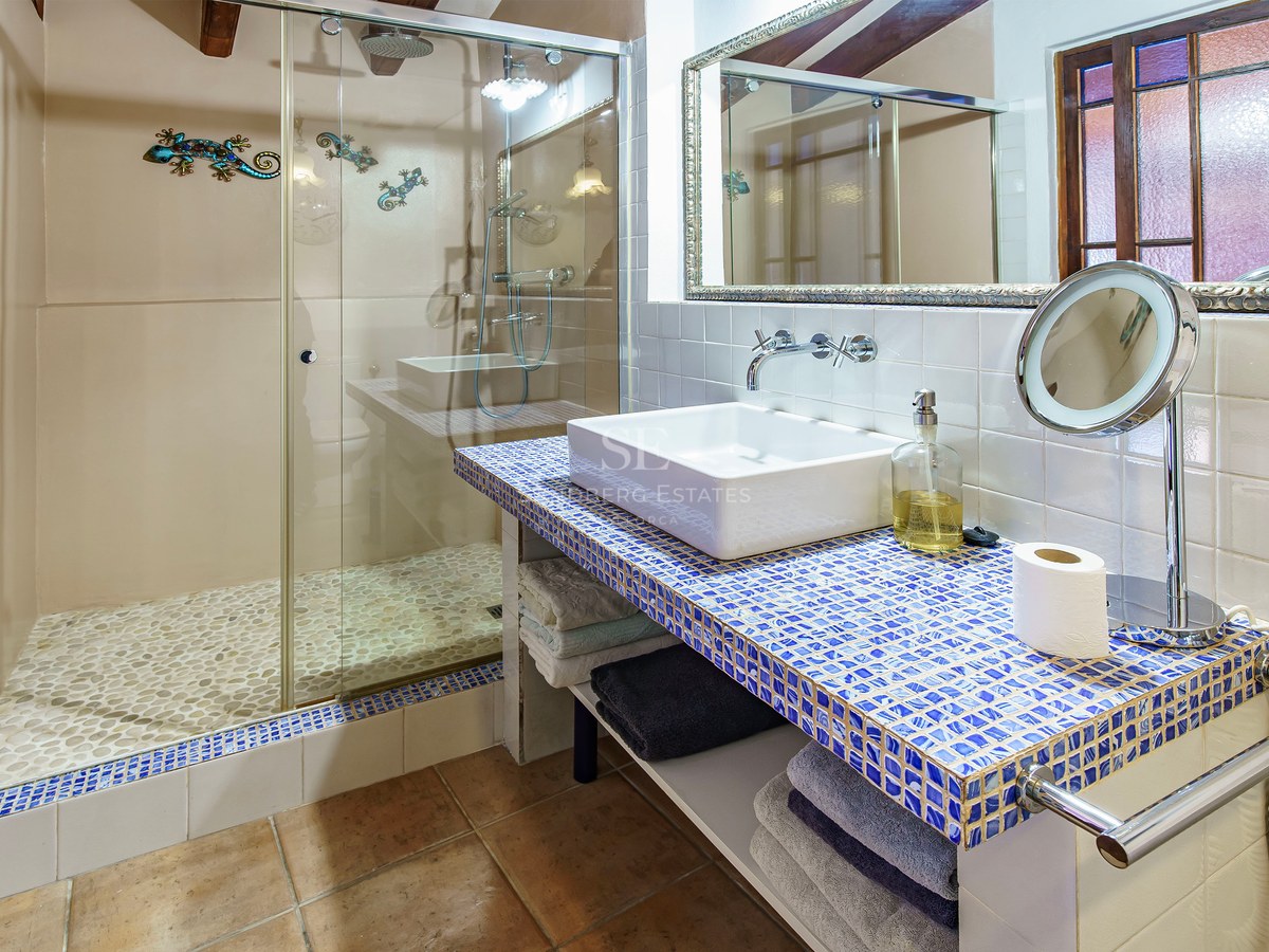 Modernes Badezimmer mit begehbarer Dusche mit Kieselboden und blauem Mosaik-Waschtisch.
